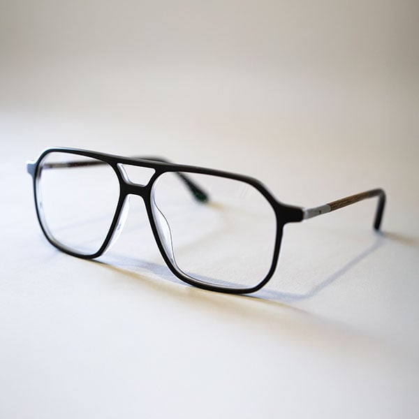 Schwarze Brille mit eckiger Fassung auf hellem Hintergrund.